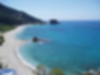 Beach view of Samos, Greece with mountain, water, sand, and some rocks