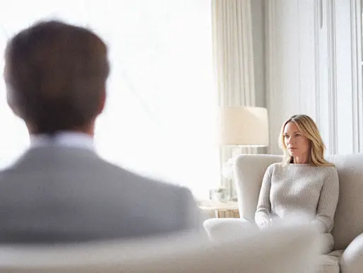 Two parents meeting with family consultants to discuss their child's mental health issues due to reported, self imposed, pressure.