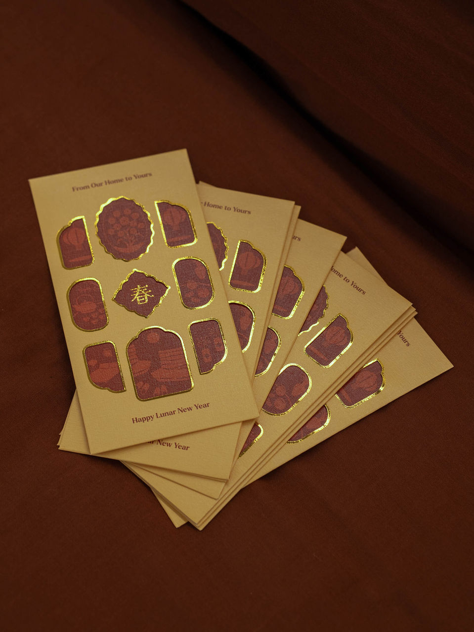 Red packet designs in yellow and orange colour on a brown colour background.