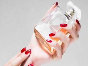 someone with red painted finger nails holding bottle of Chanel coco mademoiselle perfume