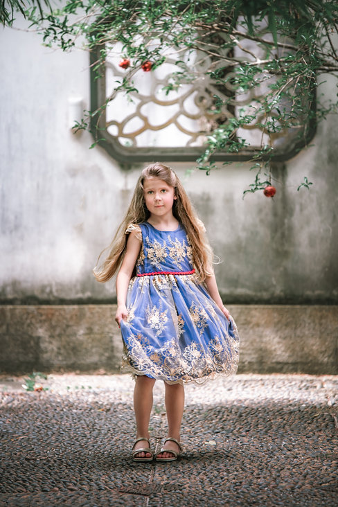 Girl in blue and gold dress with apple on tree