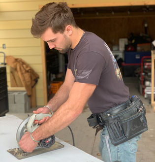 Worker Cutting Wood during TGU Home Solutions project.
