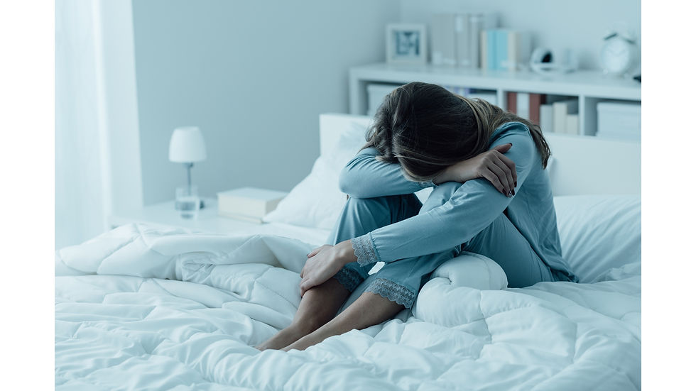 Frau, die auf dem Bett sitzt.