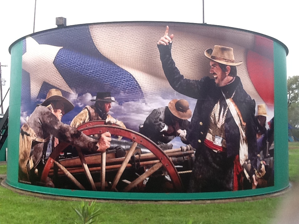 Large EPICArt historical mural installed across the curved face of an industrial storage tank
