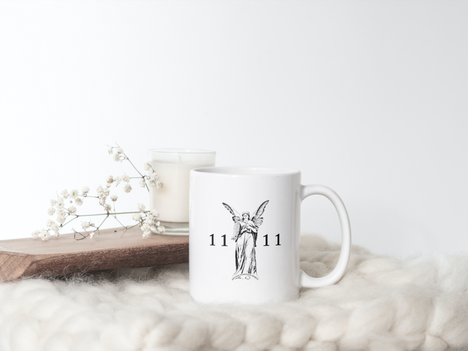 Tasse in verträumter Atmosphäre mit Wolldecke als Unterlage, Blumen und Holzbrett im Hintergrund. Tasse mit Engel Aufdruck und Engelnummer 1111
