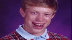 School photo of a red-haired boy in a plaid vest with braces