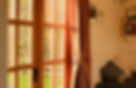 Hut interior with sunlight streaming through French doors