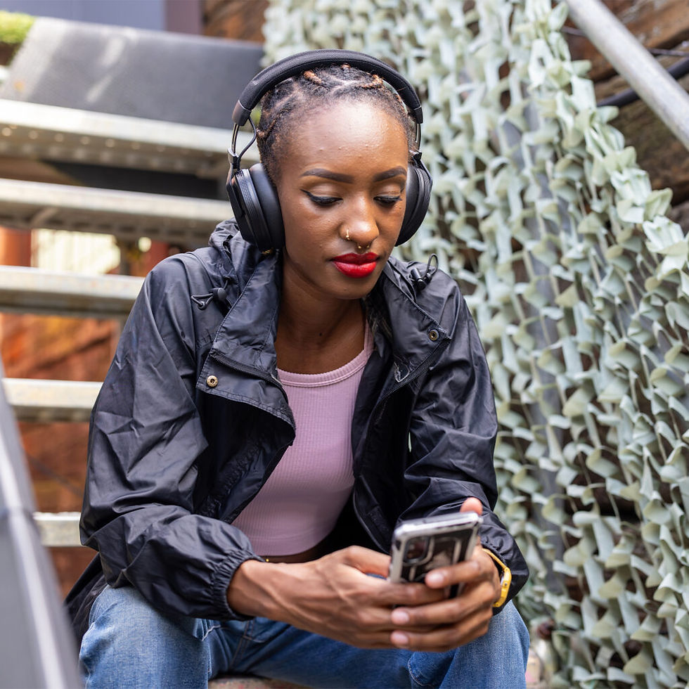 A Black female listening songs on the new AlphaTheta Pioneer Dj Headphones HDJ-F10 on her mobile phone