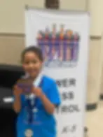 Illinois chess student holding tournament trophy after successful competition