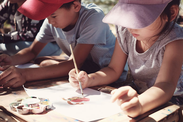 Boy and girl working on art project in the outdoors