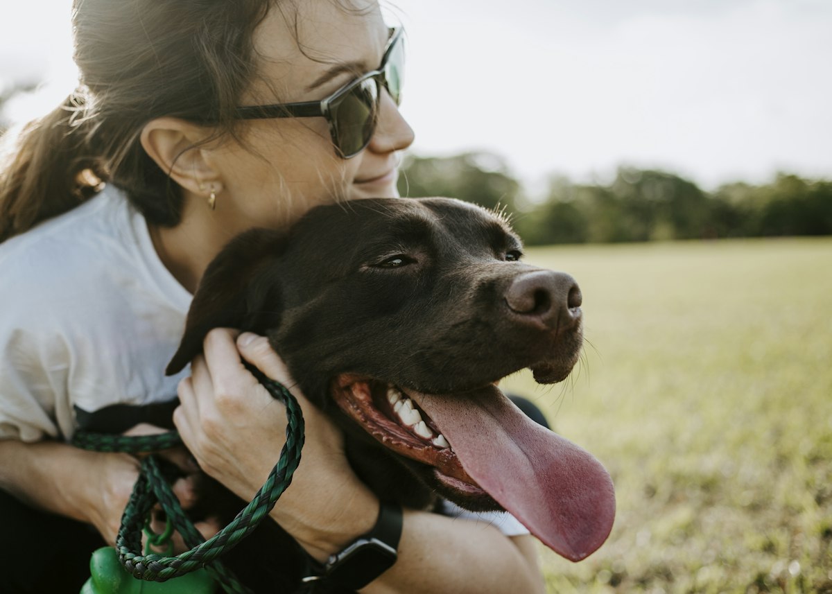A woman giving a dog a big hug