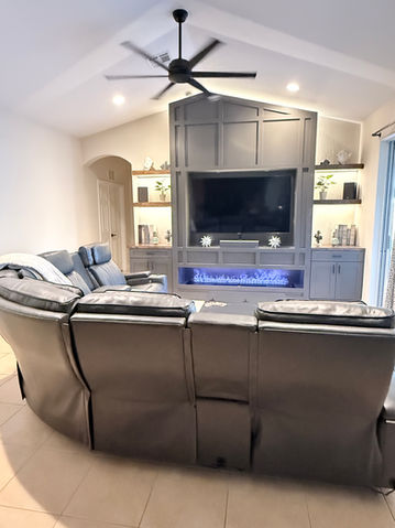 Tall dark gray media wall with fireplace burning light blue flames