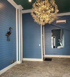 Elegant coastal exterior foyer with exquisite round chandelier. 