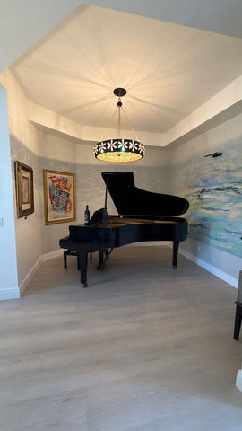 Beautful Bonita Springs room with piano and tray ceiling after remodeling by Spirit Building Group.