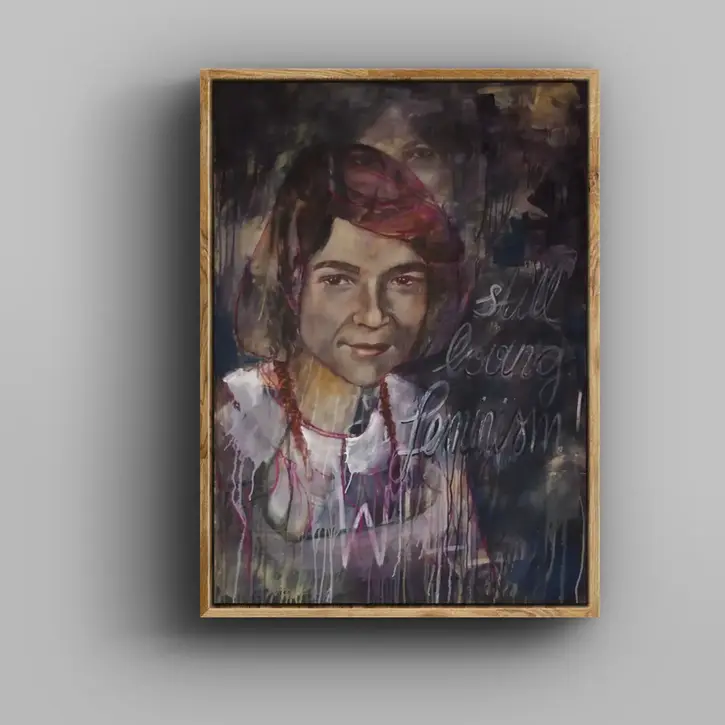 Gerahmtes Porträt einer Person mit dunklem Hintergrund. Rechts im Bild steht handschriftlich „still being feminist“.