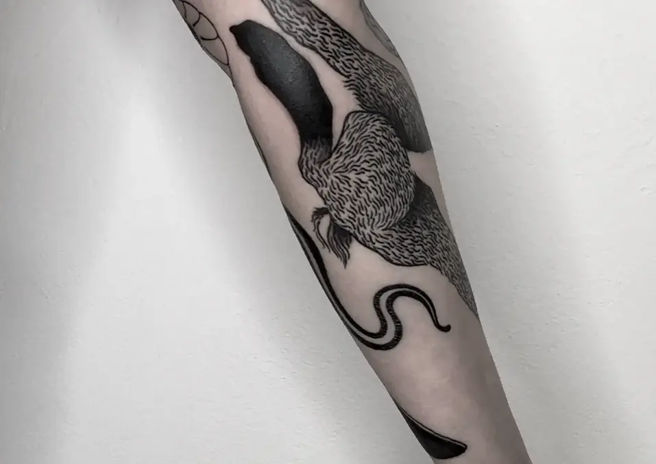 Schwarzes Schlangen-Tattoo auf einem Unterarm.