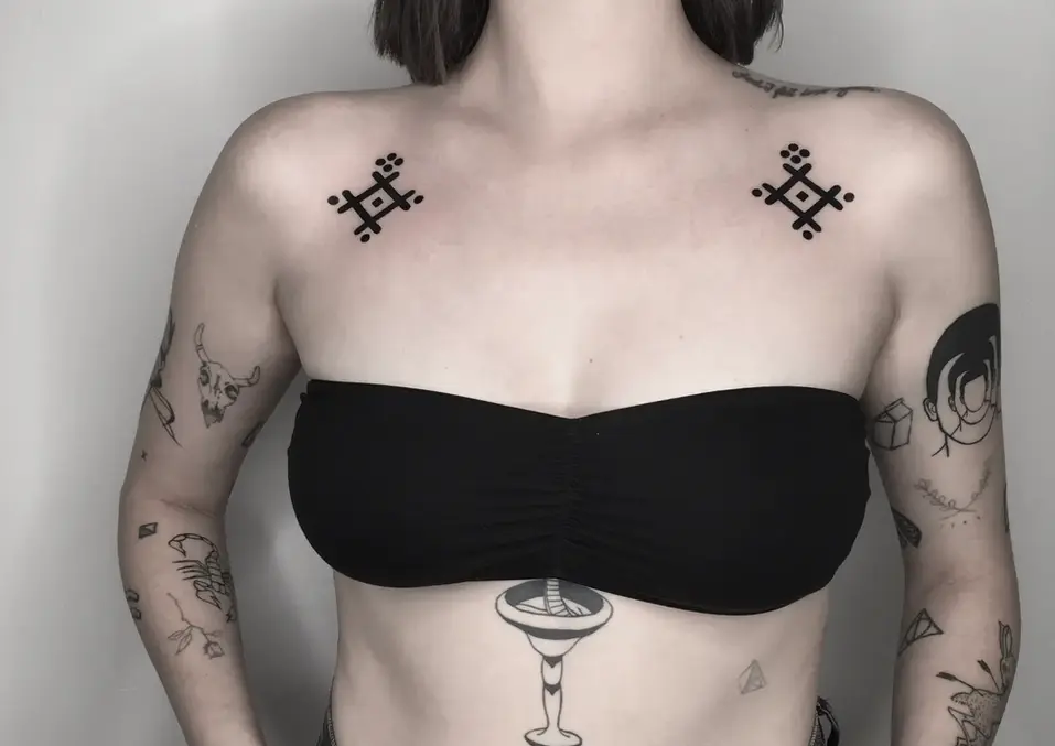 Frau mit symmetrischen Tattoos auf den Schultern und am Bauch.
