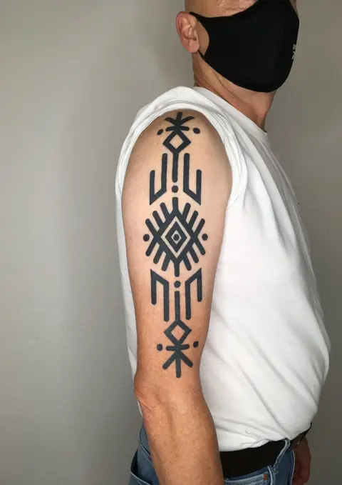 Geometrisches Tattoo auf dem Oberarm eines Mannes.