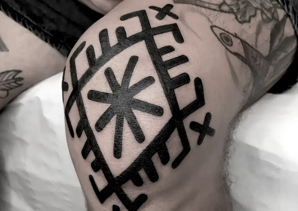Geometrisches Tattoo auf dem Knie.
