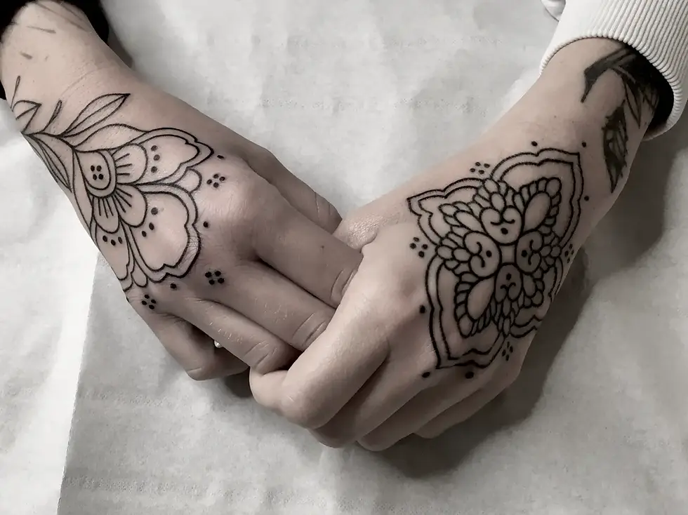 Zwei ineinanderliegende Hände mit floralen Henna-Mustern auf den Handrücken.
