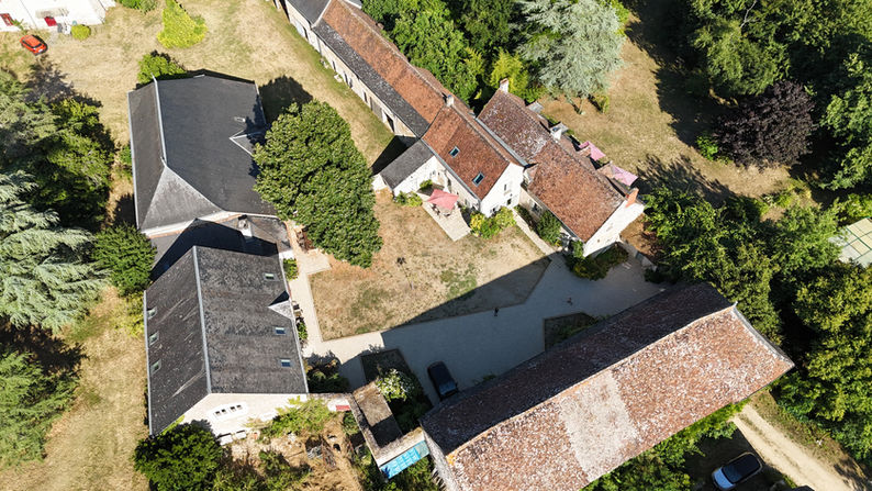 Vertical drone view of BienViennue showing buildings, parking area and greenery
