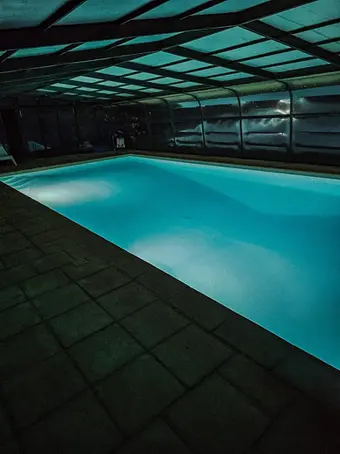 Overdekt zwembad bij avondlicht
