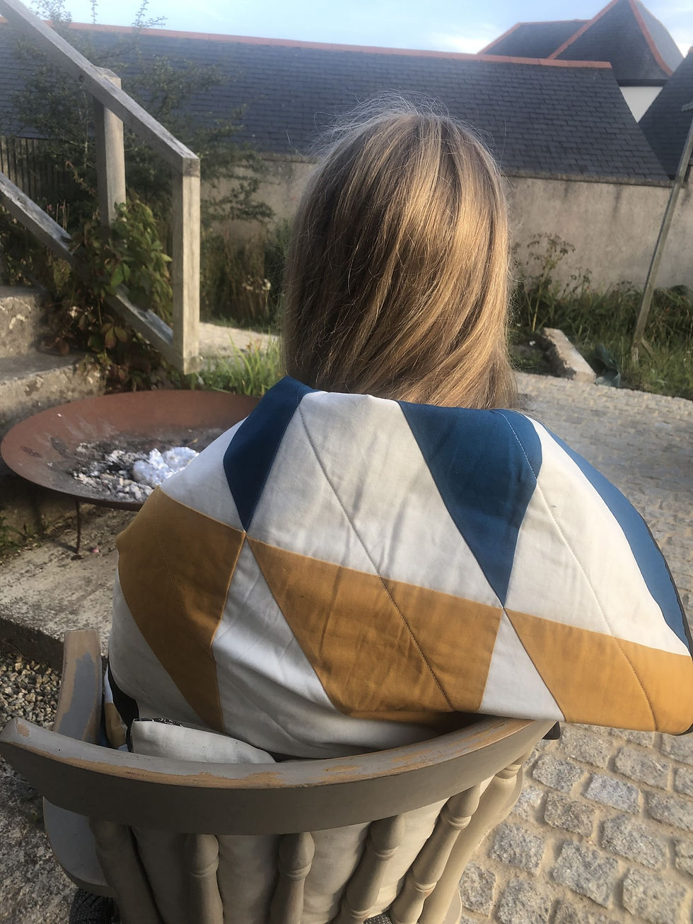 Thumbnail: Person wrapped in handmade cotton Cornish Fall quilt by Beth Osment Textiles in summer evening BBQ