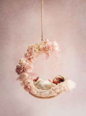 Neugeborenen Shooting im Fotostudio in einem Hängemond mit Blumen zartes rosa