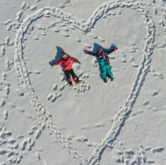 heart in snow with kids playing