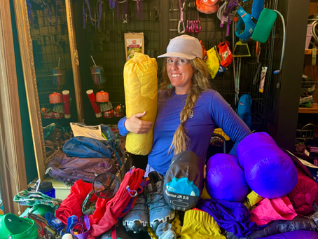 a mom in a backpacking gear locker showing gear