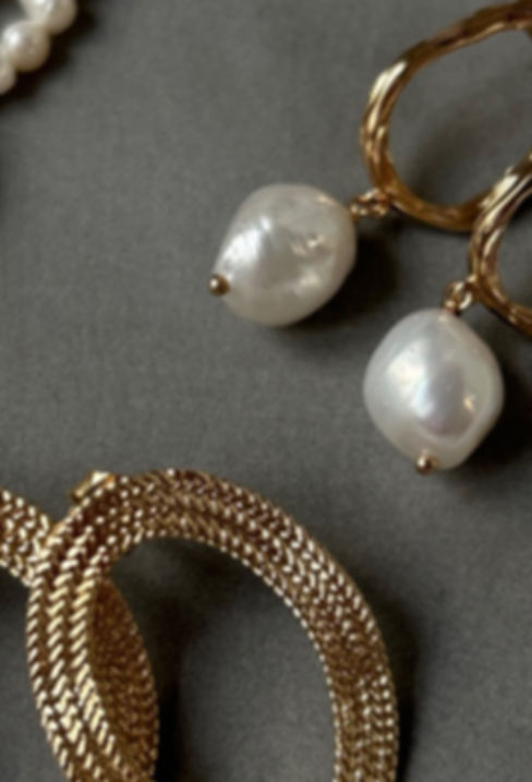 Boucles d’oreilles dorées avec perles baroques, bracelet tressé et collier en perles fines — accessoires disponibles sur l’e-shop Mademoiselle de Guise.