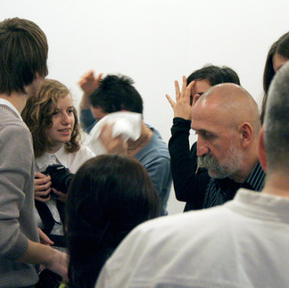 Profesorul și artistul Valeriu Mladin în dialog cu studenții săi din Departamentul Foto-Video al UNArte București. Fotografie care surprinde procesul de învățare prin desen, culoare și compoziție, în cadrul unei pedagogii bazate pe reflecție și experiment vizual. Professor and artist Valeriu Mladin in dialogue with his students from the Photo-Video Department at UNArte Bucharest. Photograph capturing the learning process through drawing, color, and composition, within a pedagogy grounded in reflection and visual experimentation.