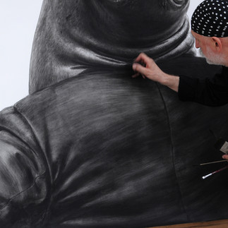 Valeriu Mladin in his studio, working on monumental drawings from the Political Bestiary series; documentary images taken over 12 years, capturing the working atmosphere, the scale of the studio, the creative process and the charcoal technique, with hybrid figures combining human bodies and animal heads.