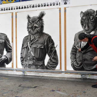 Valeriu Mladin in his studio, working on monumental drawings from the Political Bestiary series; documentary images taken over 12 years, capturing the working atmosphere, the scale of the studio, the creative process and the charcoal technique, with hybrid figures combining human bodies and animal heads.