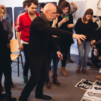 Valeriu Mladin în atelierul de desen al Universității Naționale de Arte din București, predând principiile construcției formei și ale observației vizuale. Imagine care documentează procesul pedagogic și atmosfera concentrată a atelierului universitar, parte din tradiția școlii românești de artă contemporană. Valeriu Mladin in the drawing studio of the National University of Arts Bucharest, teaching principles of form construction and visual observation. A documentary image capturing the pedagogical process and the focused atmosphere of the university studio, part of the Romanian contemporary art school tradition.