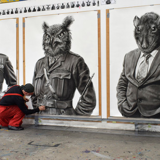 Valeriu Mladin in his studio, working on monumental drawings from the Political Bestiary series; documentary images taken over 12 years, capturing the working atmosphere, the scale of the studio, the creative process and the charcoal technique, with hybrid figures combining human bodies and animal heads.