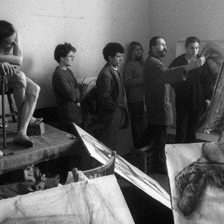 Valeriu Mladin demonstrând proporțiile corpului uman în cadrul unui curs de desen academic la UNArte București. Imagine care reflectă continuitatea studiului tradițional al desenului în arta contemporană românească. Valeriu Mladin demonstrating human body proportions during an academic drawing class at UNArte Bucharest. Image reflecting the continuity of traditional drawing study within Romanian contemporary art.