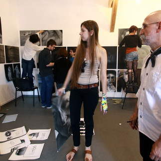 Profesorul și artistul Valeriu Mladin în dialog cu studenții săi din Departamentul Foto-Video al UNArte București. Fotografie care surprinde procesul de învățare prin desen, culoare și compoziție, în cadrul unei pedagogii bazate pe reflecție și experiment vizual. Professor and artist Valeriu Mladin in dialogue with his students from the Photo-Video Department at UNArte Bucharest. Photograph capturing the learning process through drawing, color, and composition, within a pedagogy grounded in reflection and visual experimentation.