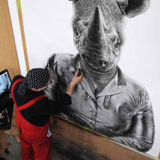 Valeriu Mladin in his studio, working on monumental drawings from the Political Bestiary series; documentary images taken over 12 years, capturing the working atmosphere, the scale of the studio, the creative process and the charcoal technique, with hybrid figures combining human bodies and animal heads.