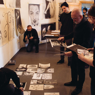 Valeriu Mladin în atelierul de desen al Universității Naționale de Arte din București, predând principiile construcției formei și ale observației vizuale. Imagine care documentează procesul pedagogic și atmosfera concentrată a atelierului universitar, parte din tradiția școlii românești de artă contemporană. Valeriu Mladin in the drawing studio of the National University of Arts Bucharest, teaching principles of form construction and visual observation. A documentary image capturing the pedagogical process and the focused atmosphere of the university studio, part of the Romanian contemporary art school tradition.