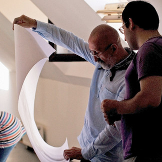 Profesorul și artistul Valeriu Mladin în dialog cu studenții săi din Departamentul Foto-Video al UNArte București. Fotografie care surprinde procesul de învățare prin desen, culoare și compoziție, în cadrul unei pedagogii bazate pe reflecție și experiment vizual. Professor and artist Valeriu Mladin in dialogue with his students from the Photo-Video Department at UNArte Bucharest. Photograph capturing the learning process through drawing, color, and composition, within a pedagogy grounded in reflection and visual experimentation.