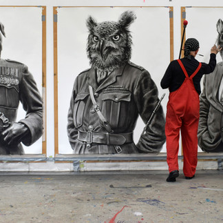 Valeriu Mladin in his studio, working on monumental drawings from the Political Bestiary series; documentary images taken over 12 years, capturing the working atmosphere, the scale of the studio, the creative process and the charcoal technique, with hybrid figures combining human bodies and animal heads.