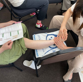 看護師。介護士、セラピスト、エステティシャンが介護施設や高齢者にハンドマッサージやマッサージを施術するために実技練習をします。