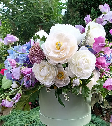 floral arrangement with white hellebore, apple blossom in pink white mix, green viburnum and ivy.