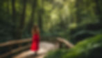woman in a red dress walking on a path in a dark green forest