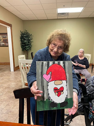 Resident proudly displaying a handmade holiday craft