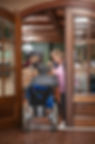 Nurse opening door for resident in a wheel chair