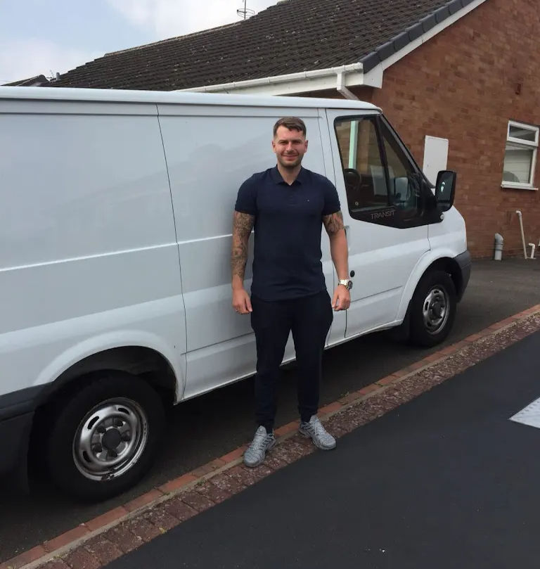 Sam Hurley of SJH Plumbing and Heating standing next to work van.