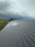 Long grey tiled roof with multiple rooflights