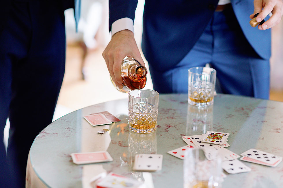 Whisky being poured and playing cards on a table